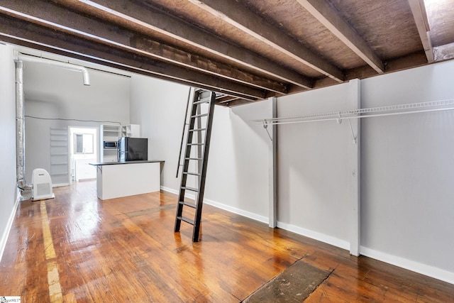 basement with hardwood / wood-style floors and black fridge