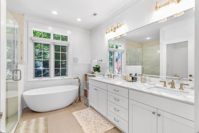 bathroom with tile floors, ornamental molding, a wealth of natural light, and double sink vanity