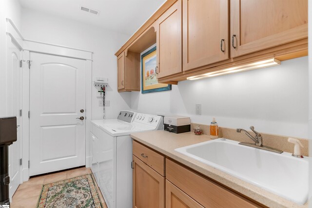 laundry area with washer and dryer, cabinets, sink, and light tile flooring