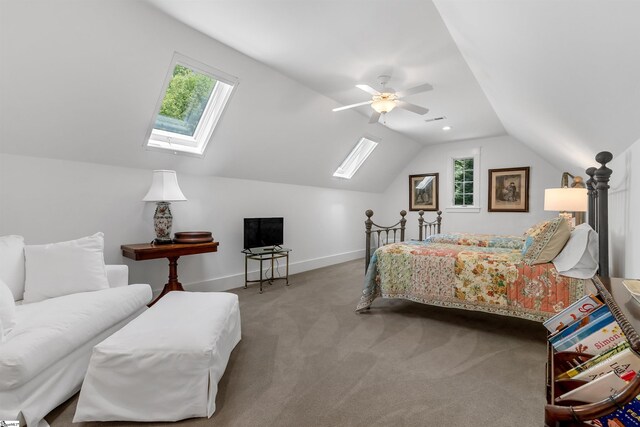 bedroom with vaulted ceiling with skylight, carpet, ceiling fan, and multiple windows