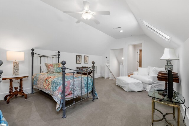 carpeted bedroom with ceiling fan and vaulted ceiling with skylight