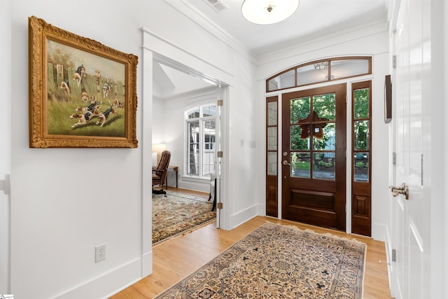 foyer featuring light hardwood / wood-style floors and crown molding