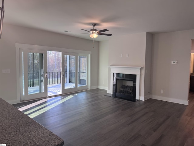 unfurnished living room with ceiling fan and dark hardwood / wood-style flooring