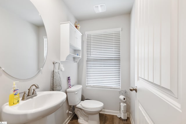 bathroom with toilet, sink, and hardwood / wood-style floors