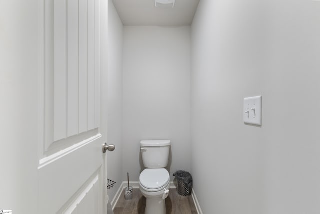 bathroom featuring wood-type flooring and toilet