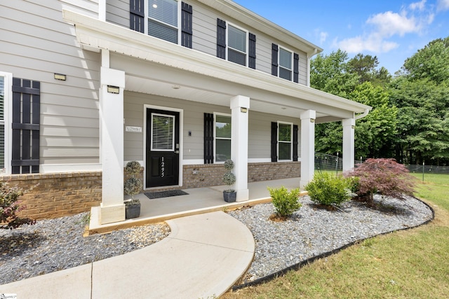 view of exterior entry featuring covered porch