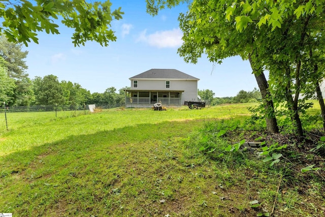 view of yard featuring a sunroom and a rural view