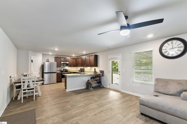 living room with ceiling fan, sink, and light hardwood / wood-style floors