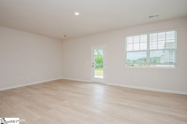 spare room featuring plenty of natural light and light hardwood / wood-style floors