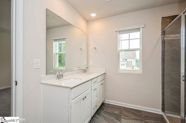 bathroom with a wealth of natural light, a shower with door, and vanity