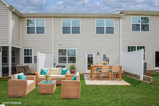 rear view of property featuring outdoor lounge area, a patio area, and a lawn