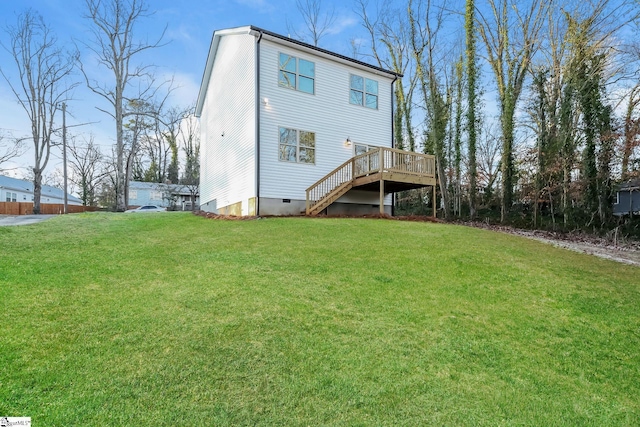 rear view of house with a lawn and a deck