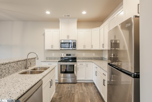 kitchen with dark wood-type flooring, sink, white cabinets, and stainless steel appliances