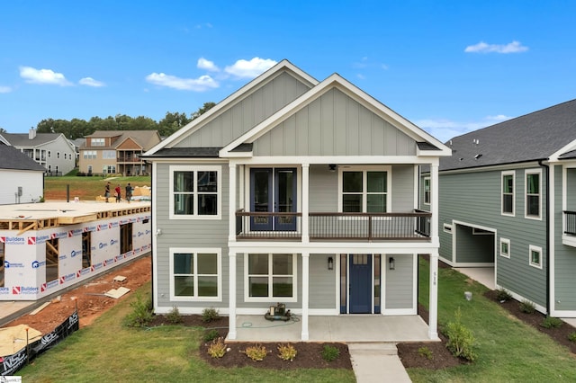 rear view of property with a yard and a balcony