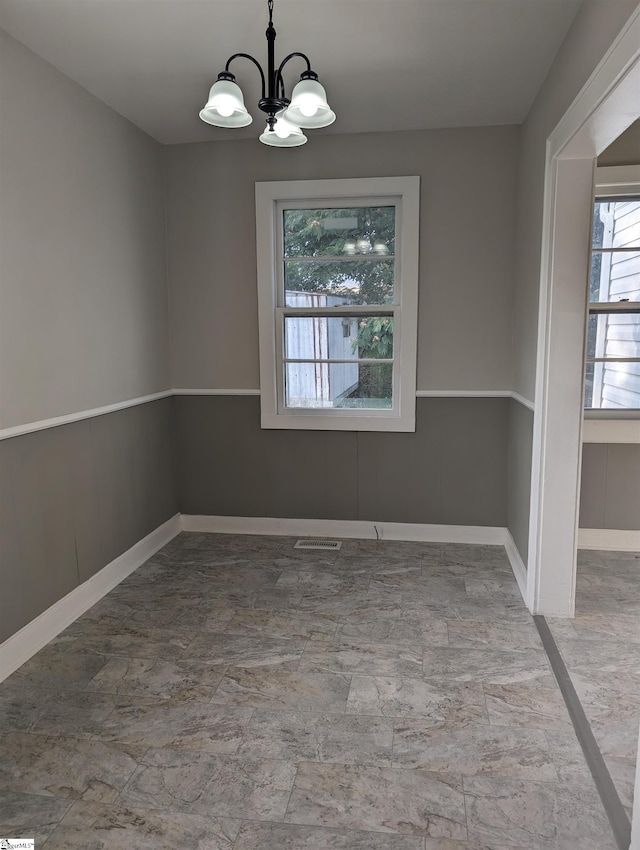 unfurnished dining area with a notable chandelier