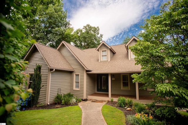 cape cod house featuring a shingled roof, a front lawn, and a porch