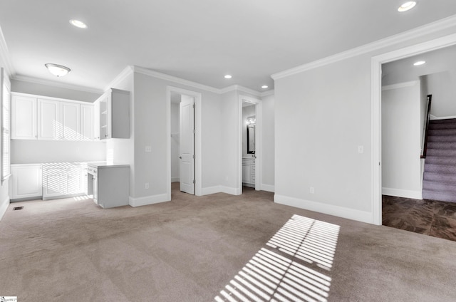 unfurnished living room featuring light colored carpet and crown molding