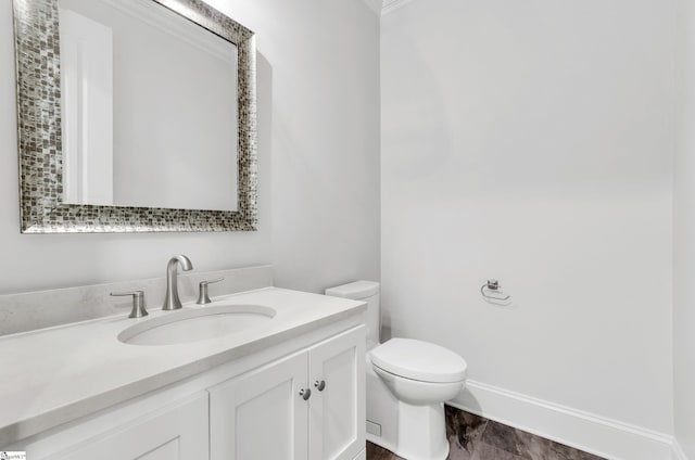 bathroom featuring toilet, vanity, and ornamental molding