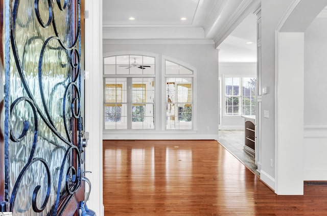 foyer entrance with ceiling fan, hardwood / wood-style flooring, and ornamental molding