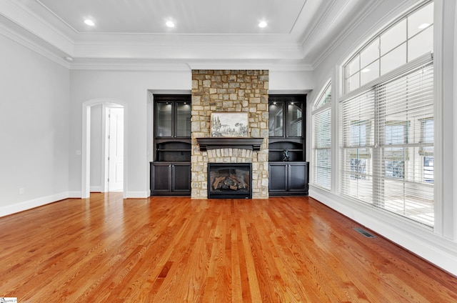 unfurnished living room featuring hardwood / wood-style flooring, ornamental molding, and a fireplace