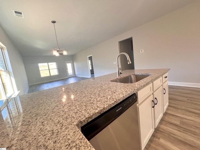 kitchen with light stone counters, a sink, visible vents, white cabinets, and stainless steel dishwasher