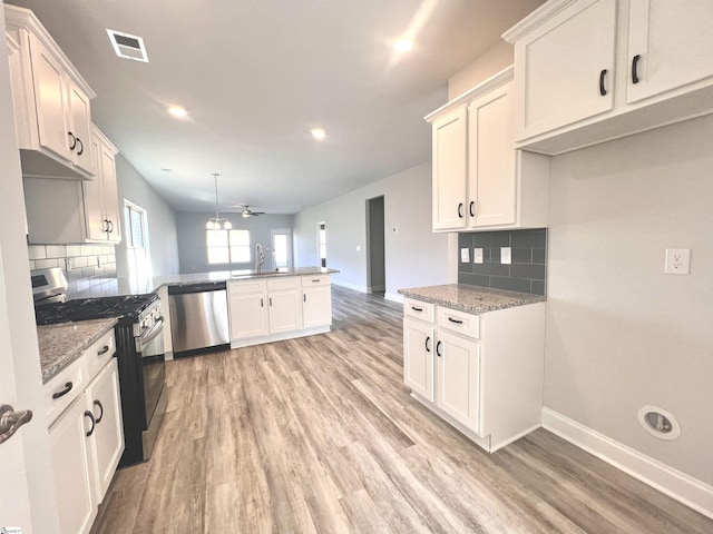 kitchen with pendant lighting, ceiling fan, decorative backsplash, appliances with stainless steel finishes, and kitchen peninsula