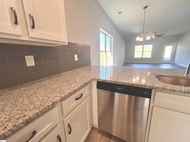 kitchen with dishwasher, a sink, white cabinets, and decorative backsplash