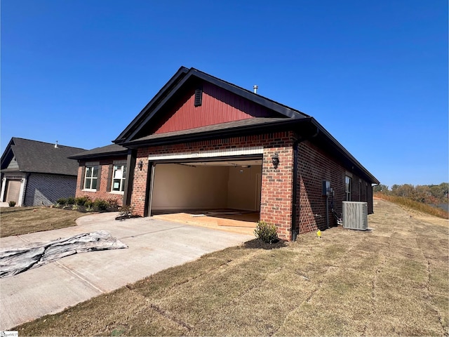 view of front of home with a front yard, cooling unit, and a garage