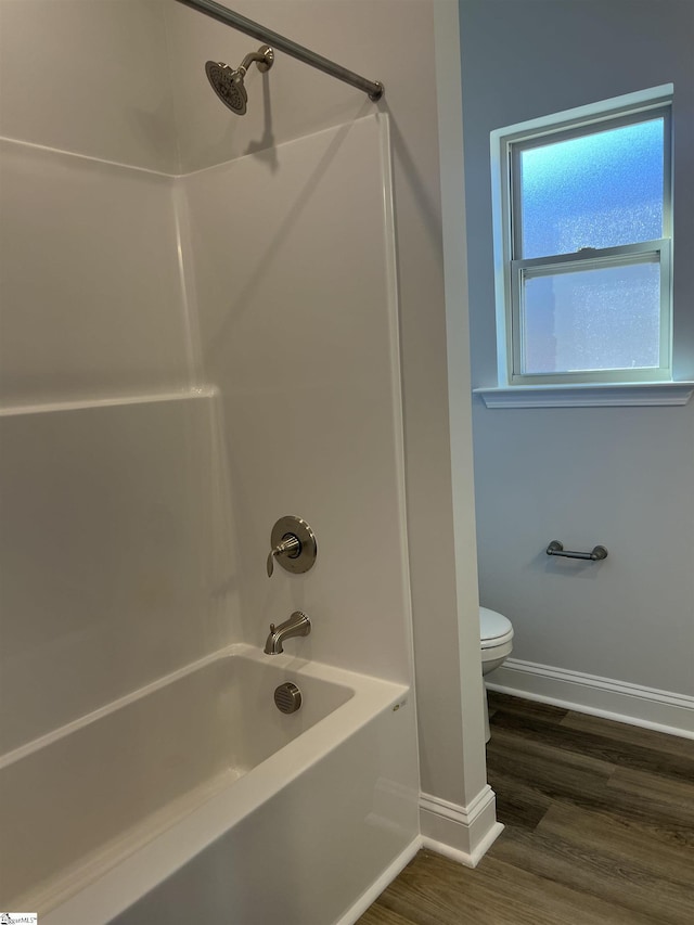 bathroom featuring toilet, hardwood / wood-style flooring, and shower / bathing tub combination