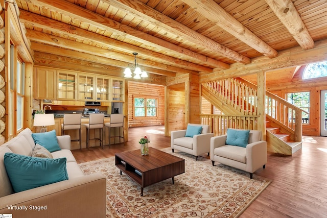 living room with wood ceiling, an inviting chandelier, rustic walls, light hardwood / wood-style flooring, and beam ceiling