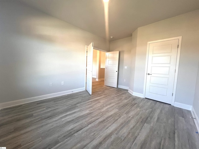 unfurnished bedroom featuring a closet and dark hardwood / wood-style floors