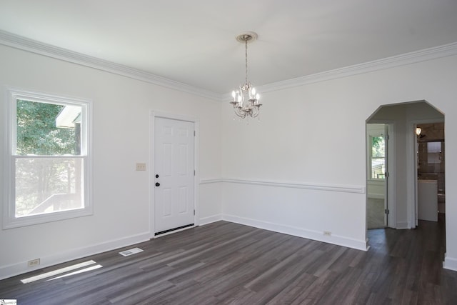 unfurnished room featuring a notable chandelier, dark hardwood / wood-style flooring, and ornamental molding