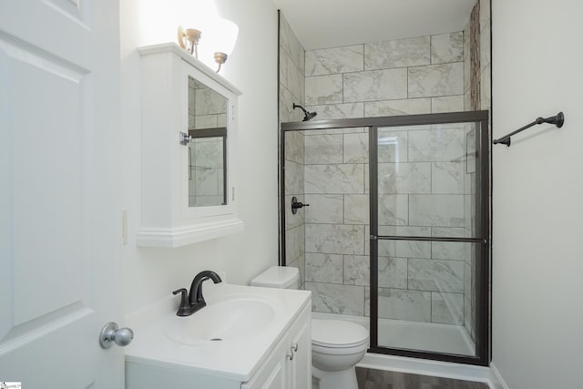 bathroom with toilet, vanity, hardwood / wood-style floors, and walk in shower