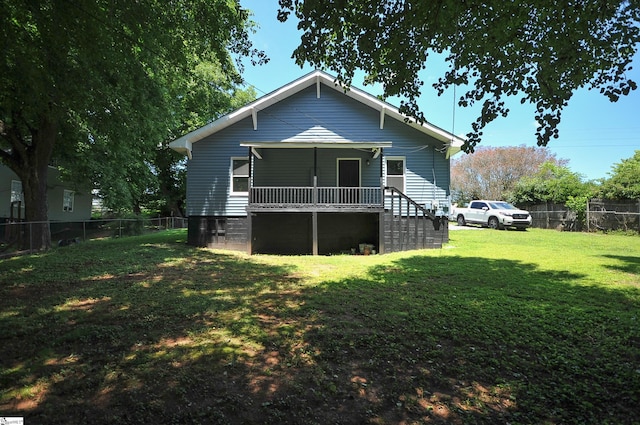 rear view of house with covered porch and a yard