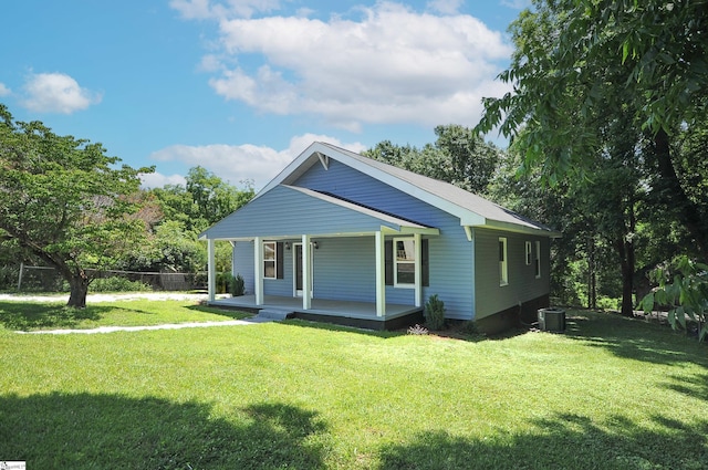 view of front of house with covered porch, cooling unit, and a front yard