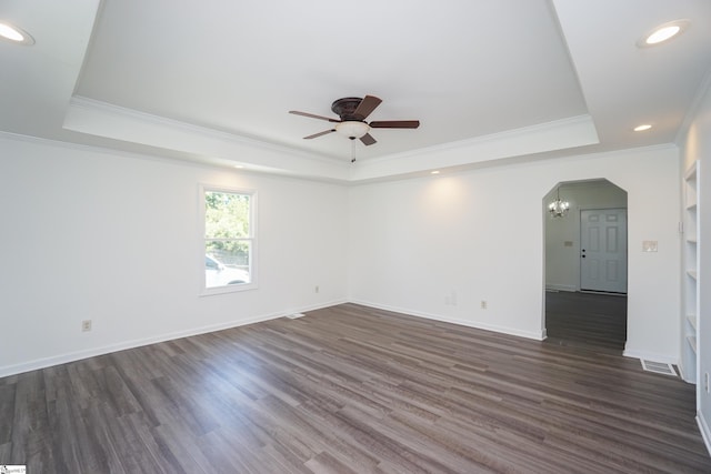 spare room with crown molding, a raised ceiling, and dark wood-type flooring