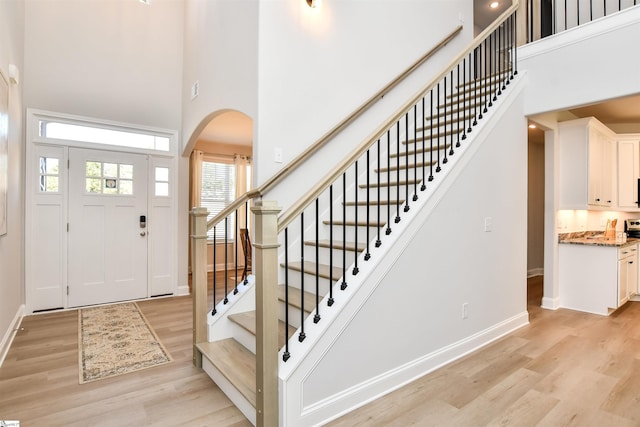 entryway with a towering ceiling and light hardwood / wood-style floors