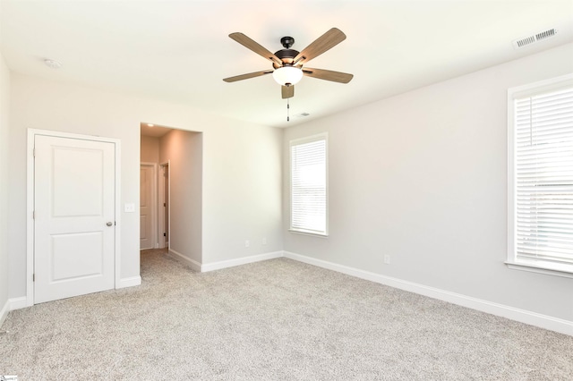 empty room with light colored carpet and ceiling fan