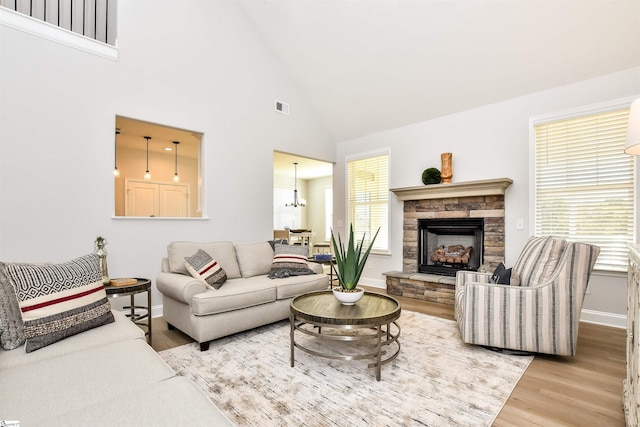 living room with high vaulted ceiling, a fireplace, and hardwood / wood-style flooring