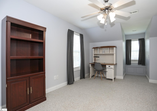 unfurnished office with light colored carpet, vaulted ceiling, and ceiling fan