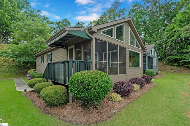 view of property exterior featuring a lawn and a sunroom