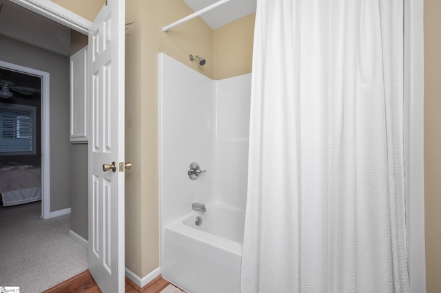 bathroom with shower / bath combination with curtain and wood-type flooring