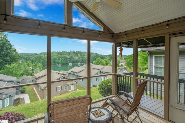 sunroom featuring lofted ceiling, a water view, ceiling fan, and a healthy amount of sunlight