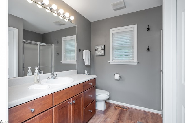 bathroom with vanity, hardwood / wood-style flooring, toilet, and a shower with shower door