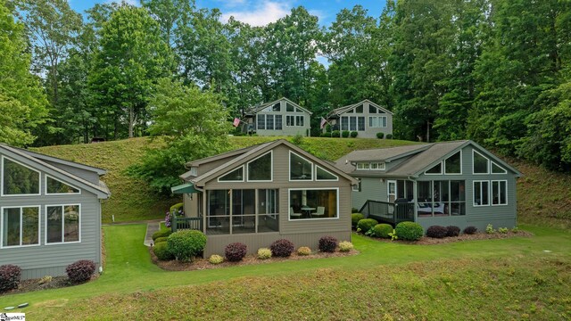 back of house featuring a sunroom and a yard