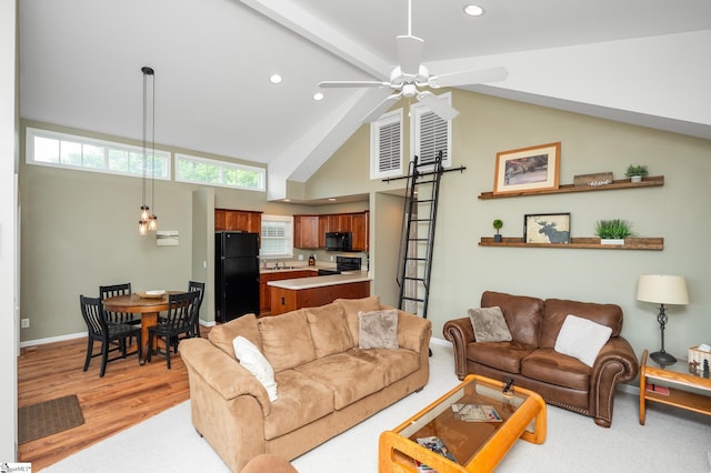 living room with ceiling fan, light hardwood / wood-style floors, and high vaulted ceiling