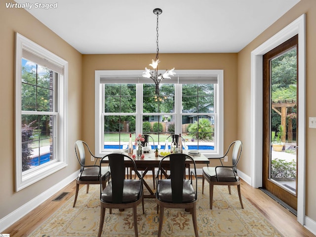 dining area featuring a notable chandelier and light wood-type flooring