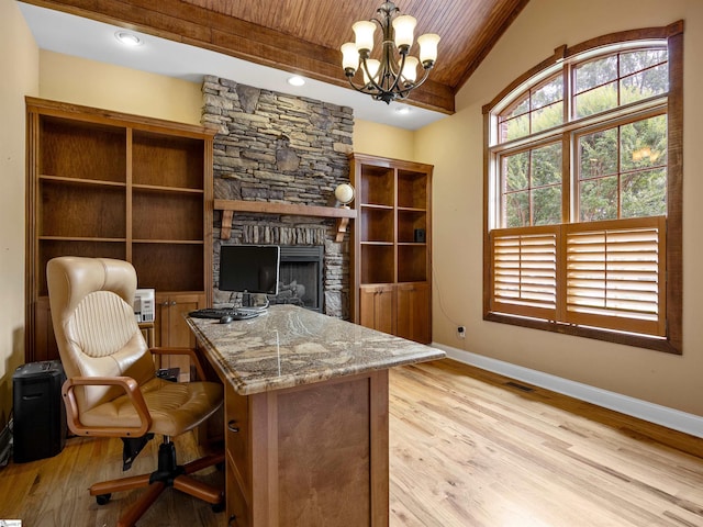 office space with wooden ceiling, beamed ceiling, a notable chandelier, a fireplace, and light wood-type flooring