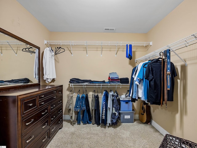 walk in closet with light carpet