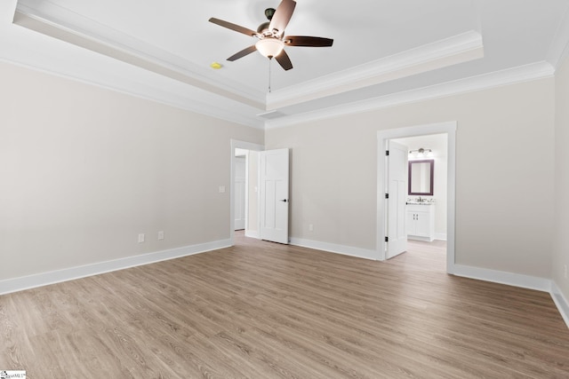 unfurnished room featuring a tray ceiling, ceiling fan, hardwood / wood-style flooring, and ornamental molding